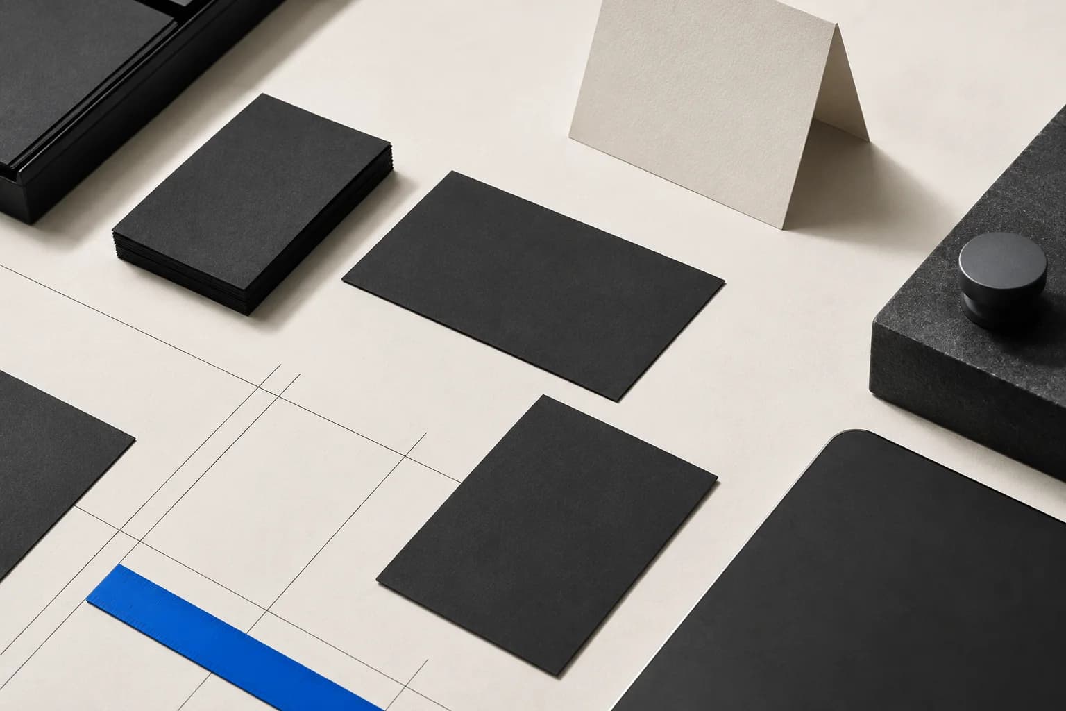 Editorial still life of black cards and a blue ruler arranged on a work surface